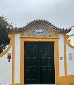un edificio con una puerta negra y una señal en él en Solar Nossa Senhora da Conceição, en Capelas