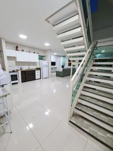 a white kitchen with a staircase in a house at Casa em Porto de Galinhas by AFT in Porto De Galinhas