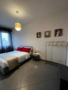 1 dormitorio con 1 cama grande con almohadas rojas en SLEEP & FLY Bergamo Centro, en Bérgamo