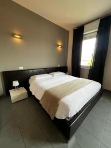 - une chambre avec un grand lit et une fenêtre dans l'établissement SLEEP & FLY Bergamo Centro, à Bergame