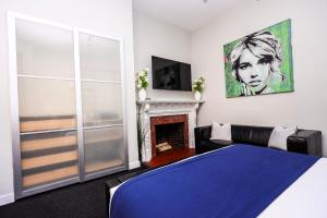 a bedroom with a blue bed and a fireplace at Large Stylish Newbury Street Studio w/ Kitchen in Boston