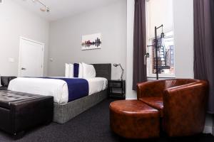 um quarto de hotel com uma cama e uma cadeira em Large Stylish Newbury Street Studio w/ Kitchen em Boston