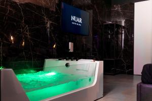 a showroom with a tv and a table with green lighting at Nuar suite&spa in Palermo