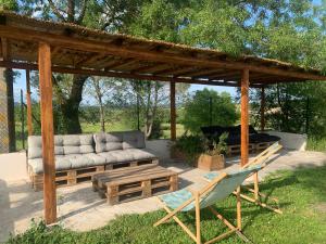 - un pavillon avec un canapé, une table et une chaise dans l'établissement LE MAS de PAUL, à Saint-Julien-de-Cassagnas