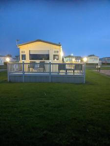 una pequeña casa con terraza en un campo en L&g FAMILY HOLIDAYS MILLFIELDS 6 BERTH FAMILYS ONLY AND THE LEAD PERSON MUST BE OVER 30s, en Ingoldmells