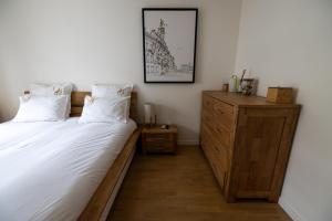 a bedroom with two beds and a wooden dresser at Le royaume de Fabrice in Suresnes