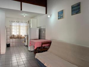 uma cozinha com um sofá, uma mesa e um frigorífico em Residencial Recanto do Sossego em Bombinhas