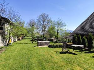 MaLu vintage house with garden في لوغانتيس: ساحة بها كراسي ومقعد في العشب