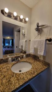 uma casa de banho com lavatório, espelho e toalhas em Nites Inn Motel em Seattle
