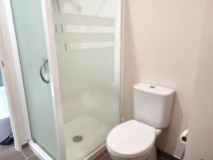 a small bathroom with a toilet and a shower at City Garden Penthouse in Auckland