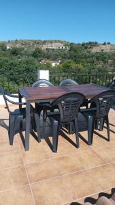 2 Holztische und -stühle auf einer Terrasse in der Unterkunft Casa Benzambra in Cádiar