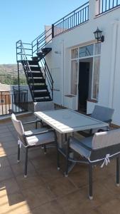 einen Tisch und Stühle auf einer Terrasse mit einer Treppe in der Unterkunft Casa Benzambra in Cádiar