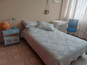 - une chambre avec un lit et une chaise bleue dans l'établissement Habitaciones en Acogedora estancia en pleno centro de Ibagué, à Ibagué