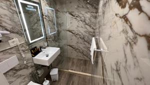 La salle de bains est pourvue d'un lavabo, de toilettes et d'un miroir. dans l'établissement Hotel Tramonto Vlore, à Vlorë