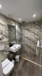 La salle de bains est pourvue d'un lavabo, de toilettes et d'une douche. dans l'établissement Hotel Tramonto Vlore, à Vlorë