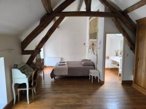 a bedroom with a bed and a desk in a room at Grande suite en duplex avec 2 chambres, terrasse dans corps de ferme in Villiers-sous-Grez