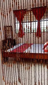 um quarto com uma cama com cortinas vermelhas em Shivalaya house 