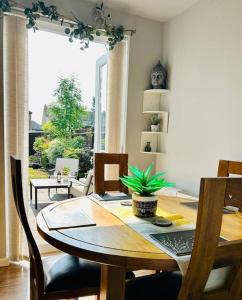d'une salle à manger avec une table en bois et une plante. dans l'établissement Heathrow's Nest, à Hayes