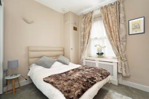 Schlafzimmer mit einem Bett und einem Fenster in der Unterkunft Covent Garden Superior Two Bedroom Aparment on Strand in London