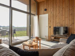 Una sala de estar con un sofá y un televisor. en Cottage in Wissenkerke near Nature Reserve, en Wissenkerke
