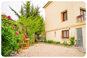 ein Haus mit einem Balkon und einigen rosa Blumen in der Unterkunft HAPPY HOUSE - PARKING - WiFI in Villiers-sur-Marne