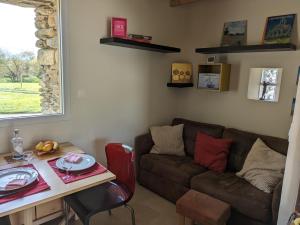 a living room with a couch and a table at Penty breton cosy in Plougonvelin