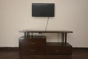 新德里的住宿－ownstay chhatarpur，一张桌子,上面有一台电视