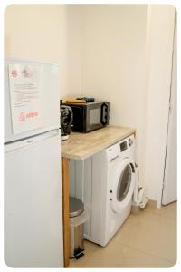 eine Küche mit einer Mikrowelle und einer Waschmaschine in der Unterkunft HAPPY HOUSE - PARKING - WiFI in Villiers-sur-Marne