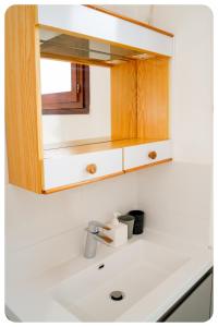 ein Waschbecken mit einem Spiegel darüber in der Unterkunft HAPPY HOUSE - PARKING - WiFI in Villiers-sur-Marne