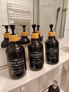 a group of four bottles of soap on a shelf at Wohlfühloase Köln 3 in Cologne