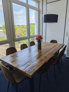 a wooden table with chairs and a vase of flowers on it at Wohlfühloase Köln 3 in Cologne