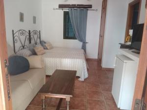 a living room with a couch and a bed at Casa Rural El Cubillo in Vejer de la Frontera