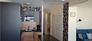 a kitchen with a sink and a table in a room at Appartement Escale Roz Pleine vue sur le Port in Perros-Guirec