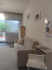 een woonkamer met een bank en een tafel bij LF_SUITE_ Lugano Lake_ Ampia Terrazza ; Spiaggia privata_ WI-FI_ Netflix_ in Porlezza