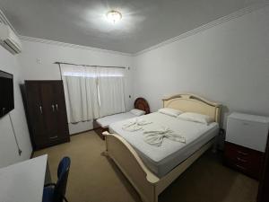 锡诺普Quarto no centro com 2 camas e hidromassagem的一间卧室配有一张床、一个梳妆台和一扇窗户。