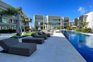 ein Resort mit einem Pool mit Liegen und Sonnenschirmen in der Unterkunft 2bdr Seven Mile Beach Corridor - ONE Canal Resort in George Town