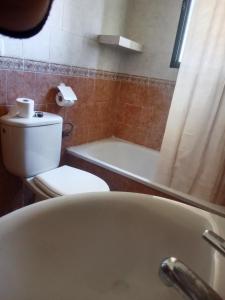 a bathroom with a tub and a toilet and a sink at Casa Rural El Cubillo in Vejer de la Frontera