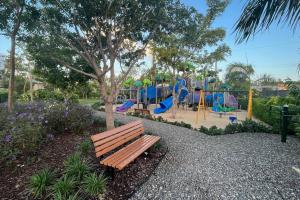 ein Park mit einer Bank neben einem Spielplatz in der Unterkunft 2bdr Seven Mile Beach Corridor - ONE Canal Resort in George Town