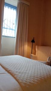 ein Schlafzimmer mit einem weißen Bett und einem Fenster in der Unterkunft Candelaria House Boutique in Bogotá