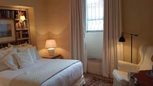 1 dormitorio con cama blanca y ventana en Candelaria House Boutique en Bogotá