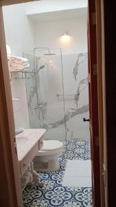 W łazience znajduje się toaleta i przeszklony prysznic. w obiekcie Candelaria House Boutique w mieście Bogota
