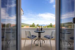 a table and chairs on a balcony with a view at Citadela Veli Lošinj in Veli Lošinj