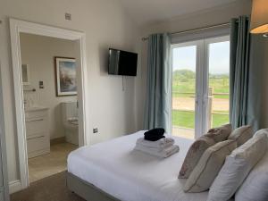 a bedroom with a bed and a sliding glass door at Seahorse Lodge at The Bay Filey, sleeps up to 6, and 2 dogs stay for free! in Filey +28 photos