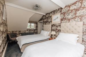 two beds in a room with floral wallpaper at Wisteria House - Sleeps 11 in Buckinghamshire
