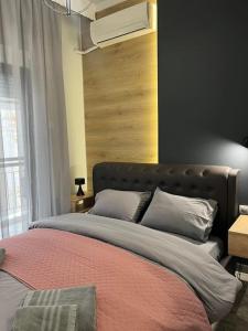 a bedroom with a large bed with a wooden headboard at Central 4 Modern Apartment with free parking in Serres