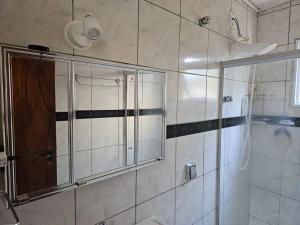a bathroom with a shower and a glass door at Casa De Itacoa in Niterói