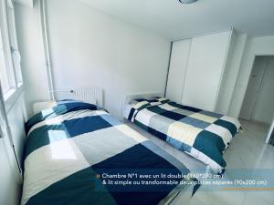 2 camas en un dormitorio pequeño con espejo en Appartement parisien 56 m2 neuf, moderne avec 2 chambres, 4 lits, parking gratuit, 15min de Paris et 13 min aéroport Orly en Vitry-sur-Seine
