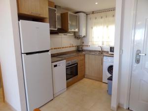 a kitchen with a white refrigerator and a dishwasher at Playa R76MED012 in La Estación