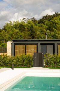 a black house with a swimming pool in front of it at LA TIERRUCA HOMES in Barcenaciones