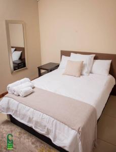 una camera da letto con un grande letto bianco e uno specchio di Su's Crest a Blantyre
